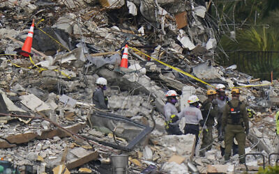 Local search and rescue personnel talk with members of an Israeli team, as they work atop the rubble at the Champlain Towers South condo building where scores of people remain missing almost a week after it partially collapsed, June 30, 2021, in Surfside, Florida. (AP Photo/Lynne Sladky) Local search and rescue personnel talk with members of an Israeli team, as they work atop the rubble at the Champlain Towers South condo building where scores of people remain missing almost a week after it partially collapsed, June 30, 2021, in Surfside, Florida. (AP Photo/Lynne Sladky)
