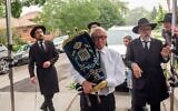 Leon Oliwkowicz carries a Torah scroll at a dedication ceremony in Chicago in 2019. (Courtesy Chabad)