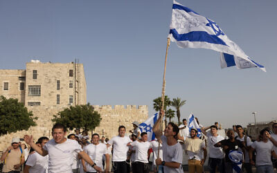Young Jewish men dance with Israeli flags near Jerusalem's Old City on Jerusalem Day, May 10, 2021. (Nati Shohat/Flash90) Young Jewish men dance with Israeli flags near Jerusalem's Old City on Jerusalem Day, May 10, 2021. (Nati Shohat/Flash90)