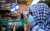 Palestinians and left-wing activists protest against the eviction of Palestinian families from their homes in the East Jerusalem neighborhood of Sheikh Jarrah, on April 16, 2021. (Yonatan Sindel/Flash90)