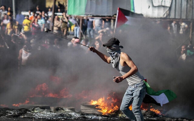 Illustrative: Palestinian protesters clash with Israeli security forces near the Hawara checkpoint, south of the West Bank city of Nablus May 18, 2021. (Nasser Ishtayeh/Flash90) Illustrative: Palestinian protesters clash with Israeli security forces near the Hawara checkpoint, south of the West Bank city of Nablus May 18, 2021. (Nasser Ishtayeh/Flash90)