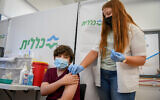 An Israeli youth receives a Covid-19 vaccine, at the Clalit Covid-19 vaccination center in Petah Tikva, on June 6, 2021. (Flash90)