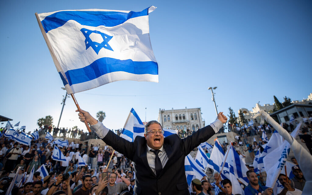 Far-right MK Itamar Ben Gvir dances with an Israeli flag at the Damascus Gate in Jerusalem's Old City, June 15, 2021. (Yonatan Sindel/Flash90)