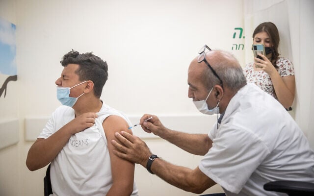 An Israeli youth receives a COVID-19 vaccine in Jerusalem on June 24, 2021. (Yonatan Sindel/Flash90) An Israeli youth receives a COVID-19 vaccine in Jerusalem on June 24, 2021. (Yonatan Sindel/Flash90)