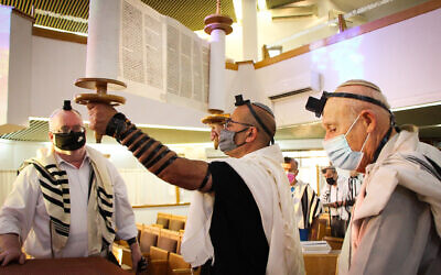 Jewish men wearing protective face masks pray at a synagogue in the Jewish settlement of Efrat, Gush Etzion, June 27, 2021. (Gershon Elinson/Flash90)