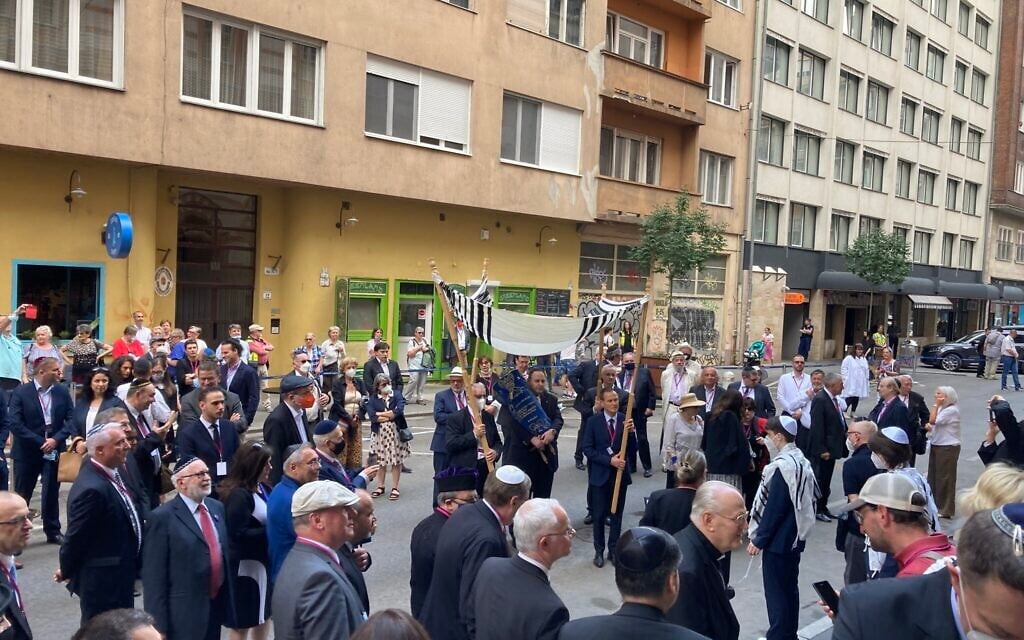 Members of the Budapest Jewish community dance with the Torah outside the Rumbach Synagogue, June 10, 2021. (Yaakov Schwartz/ Times of Israel)