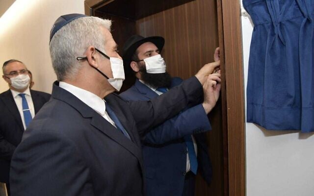 Foreign Minister Yair Lapid (L) and Chabad rabbi Levi Duchman install a mezuzah during the inauguration of the Israeli embassy in Abu Dhabi, June 29, 2021. (Shlomi Amsalem/GPO) Foreign Minister Yair Lapid (L) and Chabad rabbi Levi Duchman install a mezuzah during the inauguration of the Israeli embassy in Abu Dhabi, June 29, 2021. (Shlomi Amsalem/GPO)