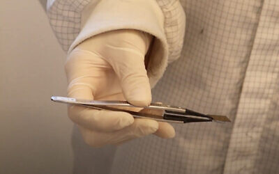 In a screenshot from video released by Tel Aviv University on June 30, PhD student Maayan Wizner Stern uses tweezers to hold an electronic storage unit that is two-atoms thick. (Screen capture: YouTube)