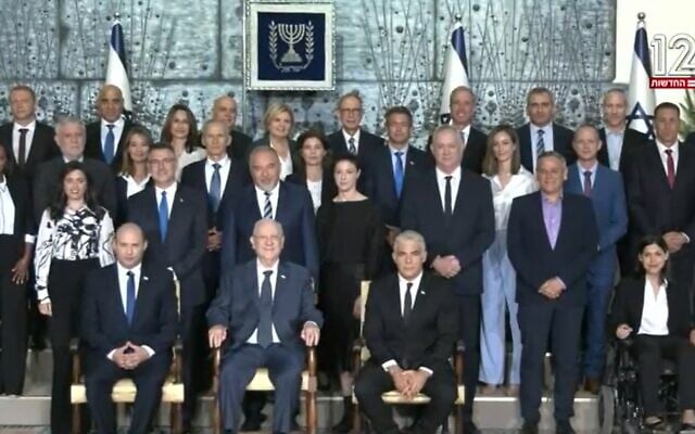 Prime Minister Naftali Bennett, President Reuven Rivlin and Alternate PM Yair Lapid (front row from left), with ministers in the new government, June 14, 2021, at the president's official residence in Jerusalem, June 14, 2021. (Screenshot: Channel 12) Prime Minister Naftali Bennett, President Reuven Rivlin and Alternate PM Yair Lapid (front row from left), with ministers in the new government, June 14, 2021, at the president's official residence in Jerusalem, June 14, 2021. (Screenshot: Channel 12)