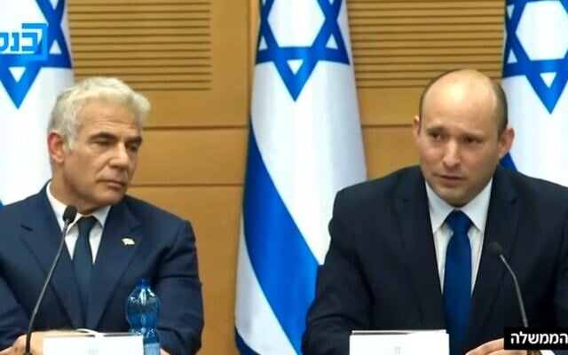 Prime Minister Naftali Bennett addresses his first cabinet meeting, with Alternate PM Yair Lapid at his side, June 13, 2021. (Channel 12 screenshot)