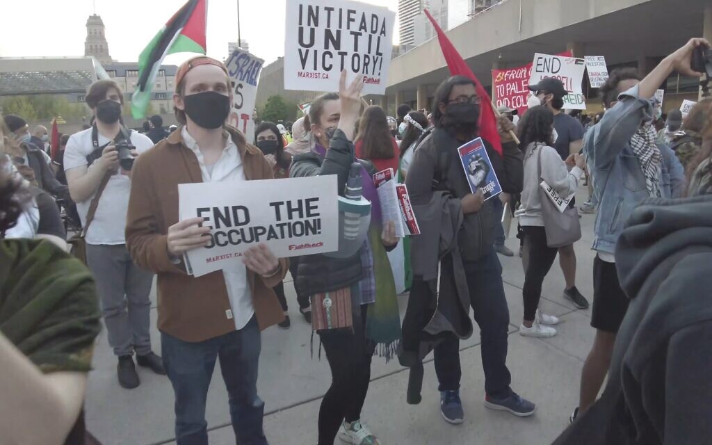 A woman holds a sign that says 'Intifada until victory' at a pro-Palestinian rally held during Israel's Operation Guardian of the Walls, in Nathan Phillips Square, downtown Toronto, May 15, 2021. (Screenshot YouTube) A woman holds a sign that says 'Intifada until victory' at a pro-Palestinian rally held during Israel's Operation Guardian of the Walls, in Nathan Phillips Square, downtown Toronto, May 15, 2021. (Screenshot YouTube)