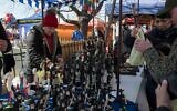 Customers at a Krakow market buy figurines of Hasidic Orthodox men. (Jason Francisco via JTA)