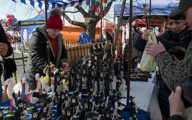 Customers at a Krakow market buy figurines of Hasidic Orthodox men. (Jason Francisco via JTA)