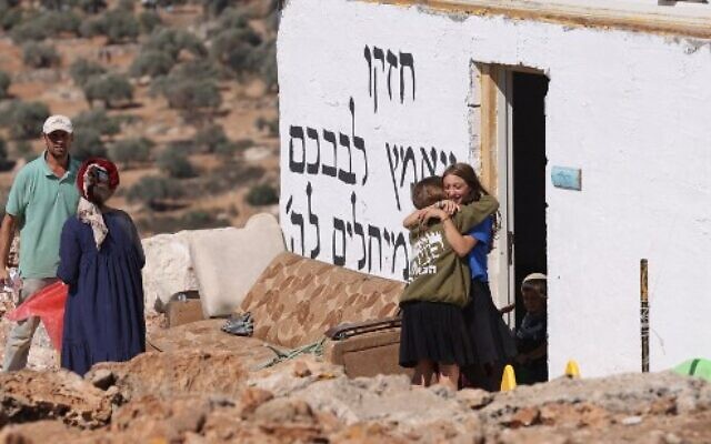 Israeli settlers bid each other farewell before evacuating the newly-established wildcat outpost of Evyatar in the West Bank, on July 2, 2021. (Photo by Emmanuel DUNAND / AFP)