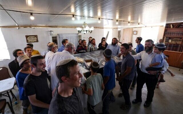 Israeli settlers dance inside a makeshift synagogue before evacuating the newly-established wildcat outpost of Evyatar in the West Bank, on July 2, 2021. (Photo by Emmanuel DUNAND / AFP)