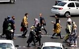 Iranians, mask-clad due to the coronavirus pandemic, cross a street in the capital Tehran, on July 3, 2021. (Atta Kenare/AFP)