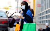 An Iranian woman, mask-clad due to the coronavirus pandemic, waits to cross a street in the capital Tehran, on July 3, 2021 (ATTA KENARE / AFP)