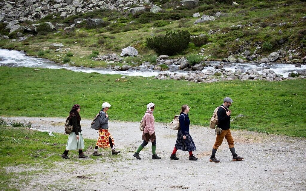 Actors of the theater group Teatro Caprile reenact an emigration scene on the old Roman road on the Windbach Alp in the Krimmler Tauern Alps on the border between Austria and Italy, near Krimml, on June 25, 2021. (ALEX HALADA/AFP)