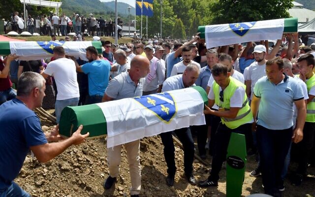 Bosnian Muslims, survivors and family members of the victims of Srebrenica 1995 massacre, carry caskets with the remains of their relatives during a burial ceremony at the memorial cemetery in village of Potocari, near the Bosnian town of Srebrenica, July 11, 2021. (Elvis Barukcic/AFP) Bosnian Muslims, survivors and family members of the victims of Srebrenica 1995 massacre, carry caskets with the remains of their relatives during a burial ceremony at the memorial cemetery in village of Potocari, near the Bosnian town of Srebrenica, July 11, 2021. (Elvis Barukcic/AFP)