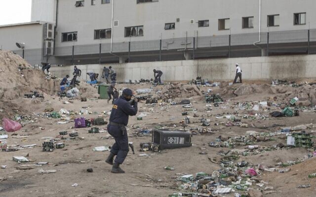 A member of the South African Police Service shoots rubber bullets to disperse looters outside a a warehouse storing alcohol in Durban on July 16, 2021, in the midst of an ongoing alcohol ban after protestors have clashed with police following a week of unrest in South Africa. (Guillem Sartorio/AFP) A member of the South African Police Service shoots rubber bullets to disperse looters outside a a warehouse storing alcohol in Durban on July 16, 2021, in the midst of an ongoing alcohol ban after protestors have clashed with police following a week of unrest in South Africa. (Guillem Sartorio/AFP)