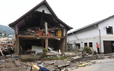A man stands in front of a destroyed house after floods caused major damage in Schuld near Bad Neuenahr-Ahrweiler, western Germany, on July 17, 2021. (CHRISTOF STACHE / AFP)