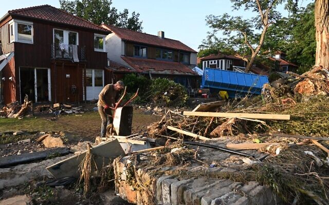 A local resident empties a wheelbarrow in the family garden in Bad Neuenahr-Ahrweiler, western Germany, on July 17, 2021. (Photo by CHRISTOF STACHE / AFP) A local resident empties a wheelbarrow in the family garden in Bad Neuenahr-Ahrweiler, western Germany, on July 17, 2021. (Photo by CHRISTOF STACHE / AFP)