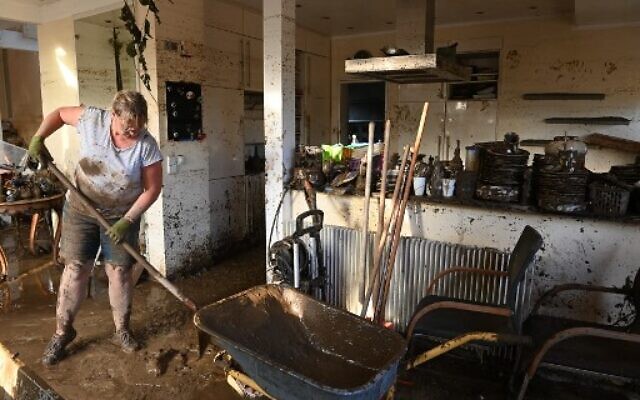 A local resident shovels mud to clear a house in Bad Neuenahr-Ahrweiler, western Germany, on July 17, 2021. (Photo by CHRISTOF STACHE / AFP) A local resident shovels mud to clear a house in Bad Neuenahr-Ahrweiler, western Germany, on July 17, 2021. (Photo by CHRISTOF STACHE / AFP)