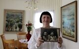 Shoshana Greenberg, 74, the daughter of a Holocaust survivor, poses for a picture holding a portrait of her parents Regina and Israel, at her home in Israeli city of Tel Aviv on July 18, 2021. (MENAHEM KAHANA / AFP)