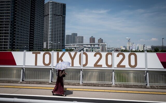 A woman walks along a street in downtown Tokyo on July 20, 2021, ahead of the Tokyo 2020 Olympic Games. (Loic VENANCE / AFP)