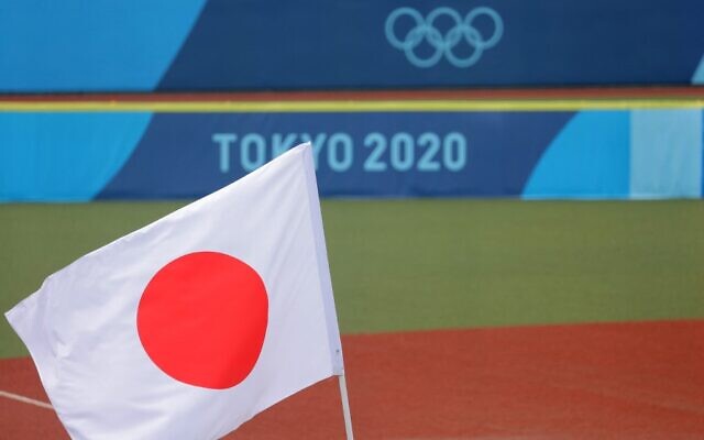 Japan's national flag is hoisted on the field prior to the Tokyo 2020 Olympic Games softball opening round game between Mexico and Japan at Fukushima Azuma Baseball Stadium in Fukushima, Japan, on July 22, 2021. (KAZUHIRO FUJIHARA / AFP)