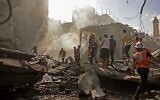 Palestinian rescuers and onlookers gather at the scene of a blast in Gaza City, the cause of which has not yet been determined, on July 22, 2021. (MOHAMMED ABED / AFP)