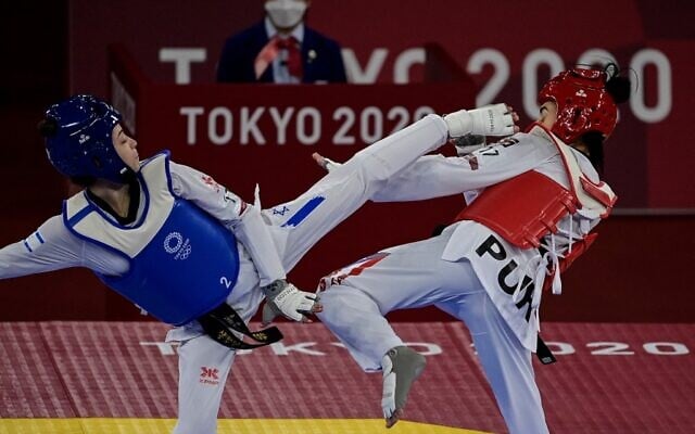 Israel's Abishag Semberg (blue) and Puerto Rico's Victoria Stambaugh (red) compete in the taekwondo women's -49kg elimination round bout during the Tokyo 2020 Olympic Games at the Makuhari Messe Hall in Tokyo on July 24, 2021. (Javier SORIANO / AFP) Israel's Abishag Semberg (blue) and Puerto Rico's Victoria Stambaugh (red) compete in the taekwondo women's -49kg elimination round bout during the Tokyo 2020 Olympic Games at the Makuhari Messe Hall in Tokyo on July 24, 2021. (Javier SORIANO / AFP)