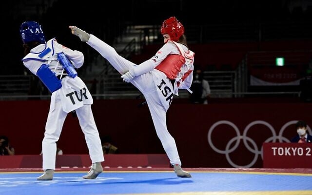 Turkey's Rukiye Yildirim (Blue) and Israel's Abishag Semberg (Red) compete in the taekwondo women's -49kg bronze medal A bout during the Tokyo 2020 Olympic Games at the Makuhari Messe Hall in Tokyo, on July 24, 2021. (Javier Soriano/AFP)