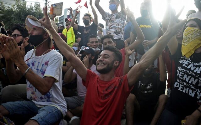 Supporters cheer outside the army-barricaded parliament building in the capital Tunis on July 26, 2021, after the president dismissed the prime minister and ordered parliament closed for 30 days (YASSINE MAHJOUB / AFP) Supporters cheer outside the army-barricaded parliament building in the capital Tunis on July 26, 2021, after the president dismissed the prime minister and ordered parliament closed for 30 days (YASSINE MAHJOUB / AFP)