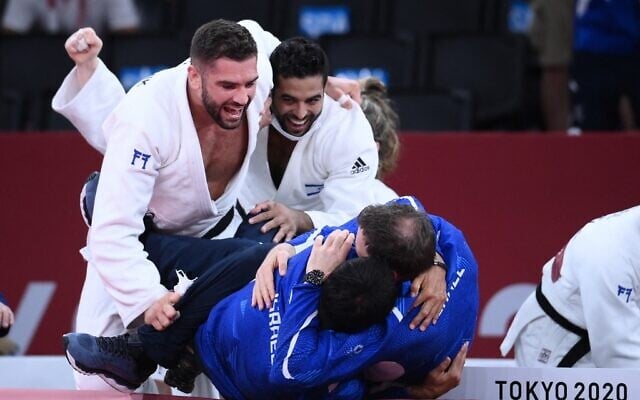 Team Israel celebrates winning the judo mixed team's bronze medal B bout against Russia during the Tokyo 2020 Olympic Games at the Nippon Budokan in Tokyo, on July 31, 2021. (Franck Fife/AFP) Team Israel celebrates winning the judo mixed team's bronze medal B bout against Russia during the Tokyo 2020 Olympic Games at the Nippon Budokan in Tokyo, on July 31, 2021. (Franck Fife/AFP)
