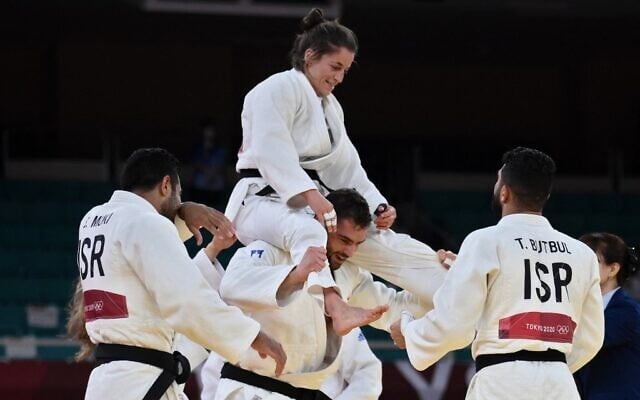 Team Israel celebrates winning the judo mixed team's bronze medal B bout against Russia during the Tokyo 2020 Olympic Games at the Nippon Budokan in Tokyo, on July 31, 2021. (Franck Fife/AFP) Team Israel celebrates winning the judo mixed team's bronze medal B bout against Russia during the Tokyo 2020 Olympic Games at the Nippon Budokan in Tokyo, on July 31, 2021. (Franck Fife/AFP)