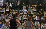 People look at a memorial that has pictures of some of the missing from the partially collapsed 12-story Champlain Towers South condo building on July 7, 2021 in Surfside, Florida. (Joe Raedle/Getty Images/AFP)
