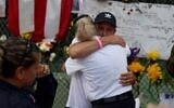 Pablo Langesfeld is hugged as he visits the memorial to the victims in the collapsed 12-story Champlain Towers South condo building as the search and rescue efforts are transitioning to a recovery operation on July 7, 2021 in Surfside, Florida. Mr. Langesfeld's daughter Nicole Langesfeld is one of the missing in the collapse of the building. (Joe Raedle/Getty Images/AFP)