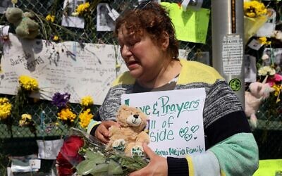 Maria Perdomo becomes emotional as she visits the memorial that includes pictures of some of the victims of the collapsed 12-story Champlain Towers South condo building on July 08, 2021 in Surfside, Florida. (Joe Raedle/Getty Images/AFP)