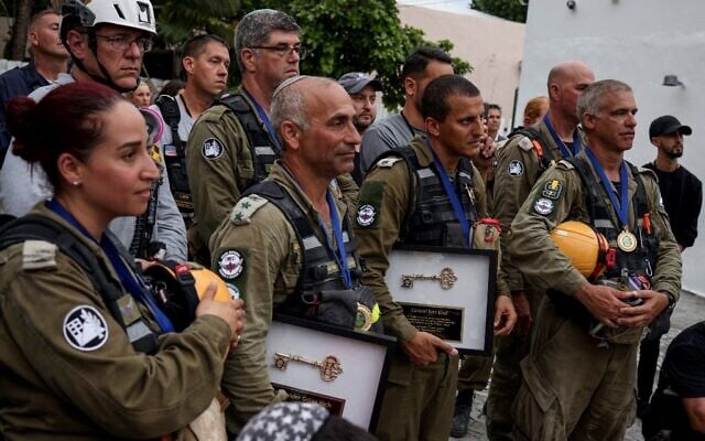 Members of the Israel Defense Forces (IDF) National Rescue Unit, including Colonel Golan Vach (2nd-L) and Colonel Edri Elad (2nd-R) hold ceremonial keys during a send off ceremony in Surfside, Florida, in July 10, 2021. (Anna Moneymaker / GETTY IMAGES NORTH AMERICA / Getty Images via AFP) Members of the Israel Defense Forces (IDF) National Rescue Unit, including Colonel Golan Vach (2nd-L) and Colonel Edri Elad (2nd-R) hold ceremonial keys during a send off ceremony in Surfside, Florida, in July 10, 2021. (Anna Moneymaker / GETTY IMAGES NORTH AMERICA / Getty Images via AFP)