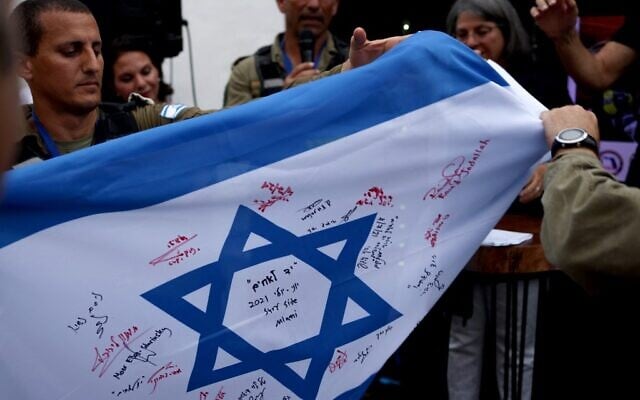 The Flag of Israel, signed by members of the Israel Defense Forces (IDF) National Rescue Unit is presented to Surfside officials on July 10, 2021 in Surfside, Florida (Anna Moneymaker / GETTY IMAGES NORTH AMERICA / Getty Images via AFP) The Flag of Israel, signed by members of the Israel Defense Forces (IDF) National Rescue Unit is presented to Surfside officials on July 10, 2021 in Surfside, Florida (Anna Moneymaker / GETTY IMAGES NORTH AMERICA / Getty Images via AFP)
