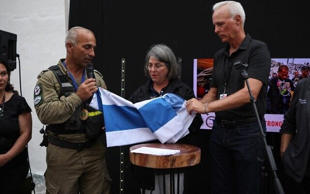 IDF Colonel Golan Vach (2nd-L) presents the Flag of Israel, signed by members of the Israel Defense Forces National Rescue Unit to Miami-Dade County Mayor Daniella Levine Cava (C) and Surfside Mayor Charles Burkett (R) on July 10, 2021 in Surfside, Florida. (Anna Moneymaker/Getty Images/AFP (Photo by Anna Moneymaker / GETTY IMAGES NORTH AMERICA / Getty Images via AFP) IDF Colonel Golan Vach (2nd-L) presents the Flag of Israel, signed by members of the Israel Defense Forces National Rescue Unit to Miami-Dade County Mayor Daniella Levine Cava (C) and Surfside Mayor Charles Burkett (R) on July 10, 2021 in Surfside, Florida. (Anna Moneymaker/Getty Images/AFP (Photo by Anna Moneymaker / GETTY IMAGES NORTH AMERICA / Getty Images via AFP)