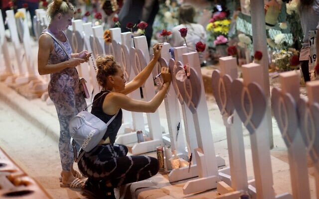 People visit the memorial that has pictures of some of the victims from the partially collapsed 12-story Champlain Towers South condo building on July 15, 2021 in Surfside, Florida. (JOE RAEDLE / GETTY IMAGES NORTH AMERICA / Getty Images via AFP) People visit the memorial that has pictures of some of the victims from the partially collapsed 12-story Champlain Towers South condo building on July 15, 2021 in Surfside, Florida. (JOE RAEDLE / GETTY IMAGES NORTH AMERICA / Getty Images via AFP)