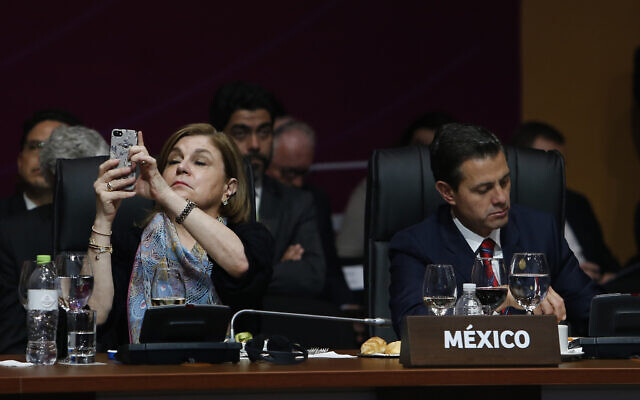 Mexico's then-president Enrique Pena Nieto takes notes as an unidentified Mexican diplomat takes pictures with her mobile phone during the plenary session at the Americas Summit in Lima, Peru, Saturday, April 14, 2018. (AP/Karel Navarro) Mexico's then-president Enrique Pena Nieto takes notes as an unidentified Mexican diplomat takes pictures with her mobile phone during the plenary session at the Americas Summit in Lima, Peru, Saturday, April 14, 2018. (AP/Karel Navarro)