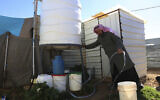 Illustrative: A Syrian man fills a bucket with water inside Zaatari, the largest camp for Syrian refugees in Mafraq, Jordan, on Sunday, Feb. 3, 2019.  (AP/Raad Adayleh)