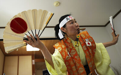Olympic fan Kyoko Ishikawa shows her cheering at her home, April 10, 2021, in Tokyo. (AP/Eugene Hoshiko)