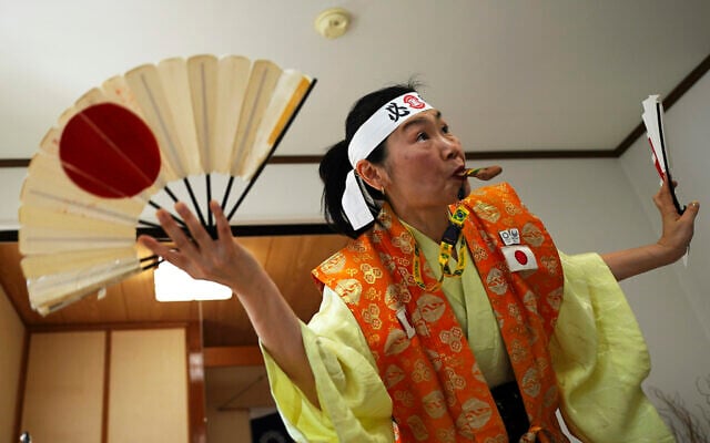 Olympic fan Kyoko Ishikawa shows her cheering at her home, April 10, 2021, in Tokyo. (AP/Eugene Hoshiko) Olympic fan Kyoko Ishikawa shows her cheering at her home, April 10, 2021, in Tokyo. (AP/Eugene Hoshiko)