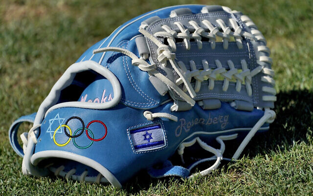 The glove of Israel Olympic baseball player Jake Roseberg sits on the field at Salt River Fields spring training facility, Wednesday, May 12, 2021, in Scottsdale, Arizona. Israel has qualified for the six-team baseball tournament at the Tokyo Olympic games which will be its first appearance at the Olympics in any team sport since 1976. (AP Photo/Matt York) The glove of Israel Olympic baseball player Jake Roseberg sits on the field at Salt River Fields spring training facility, Wednesday, May 12, 2021, in Scottsdale, Arizona. Israel has qualified for the six-team baseball tournament at the Tokyo Olympic games which will be its first appearance at the Olympics in any team sport since 1976. (AP Photo/Matt York)