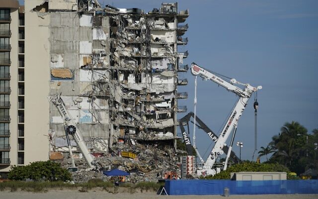 Workers peer up at the rubble pile at the partially collapsed Champlain Towers South condo building, on Thursday, July 1, 2021, in Surfside, Florida (AP Photo/Mark Humphrey) Workers peer up at the rubble pile at the partially collapsed Champlain Towers South condo building, on Thursday, July 1, 2021, in Surfside, Florida (AP Photo/Mark Humphrey)