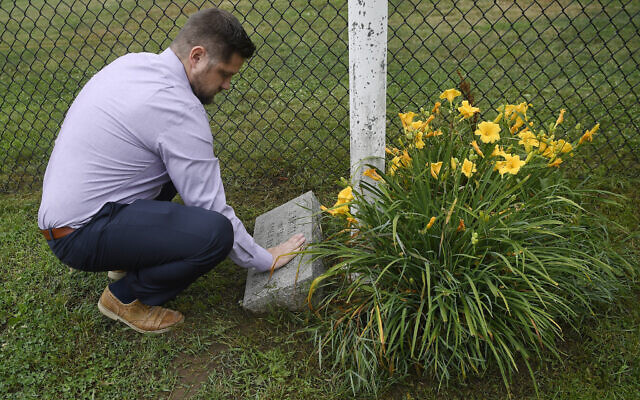 Brett Eagleson, son of September 11 victim Bruce Eagleson, wipes grass off a memorial stone for his father at the baseball field where his father use to coach on July 2, 2021, in Middletown, Connecticut (AP Photo/ Jessica Hill) Brett Eagleson, son of September 11 victim Bruce Eagleson, wipes grass off a memorial stone for his father at the baseball field where his father use to coach on July 2, 2021, in Middletown, Connecticut (AP Photo/ Jessica Hill)